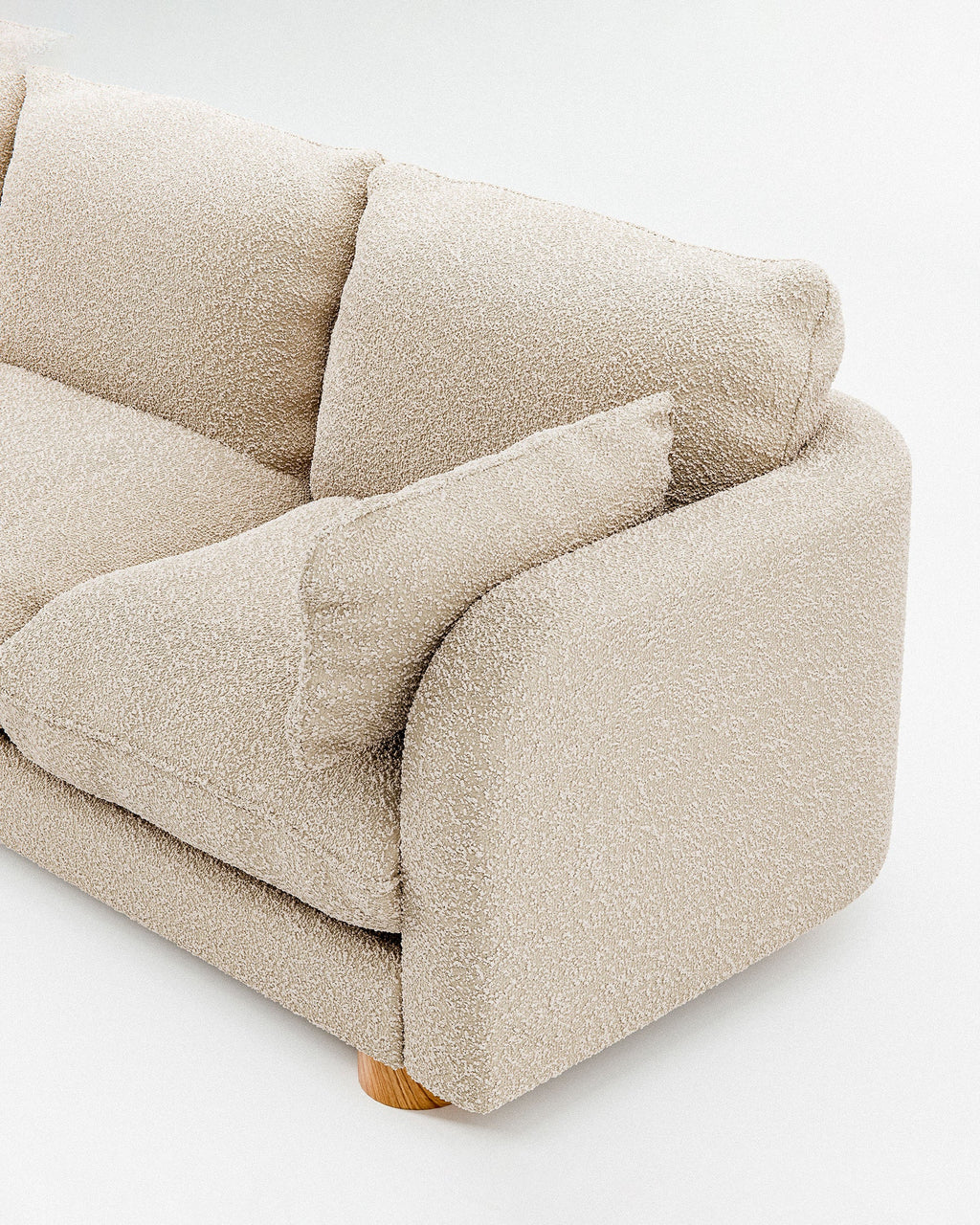 Miles treseters sofa i beige bouclé med sylindriske eikeben